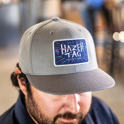 Front of a grey hat with the Hazer Tag logo