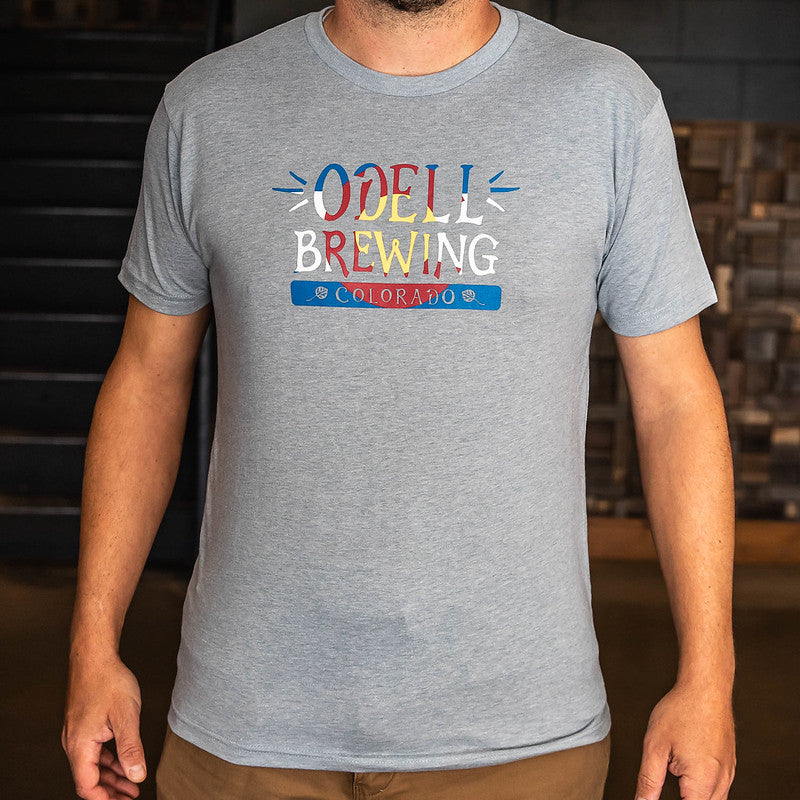 Grey shirt with Odell Brewing in writing with Colorado flag background