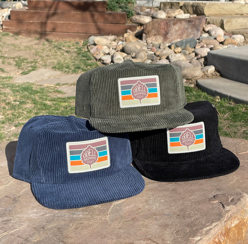 Three corduroy hats in blue, black, and green colors