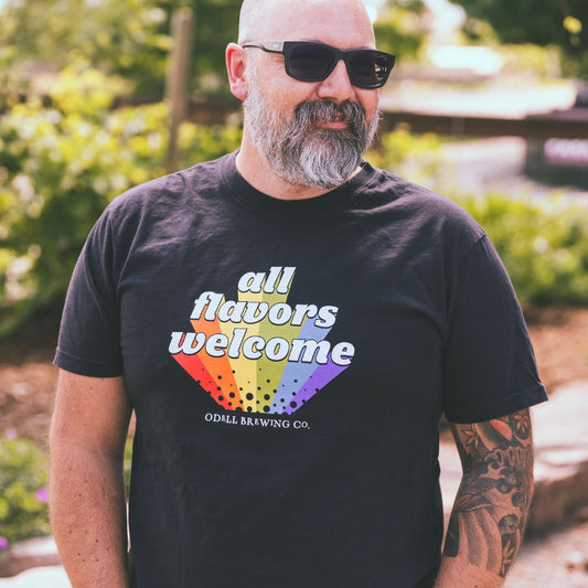 Black tee front with rainbow all flavors welcome text and odell brewing type logo
