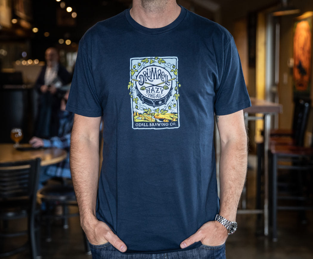 A blue t-shirt with the Drumroll Hazy Pale Ale logo on the front