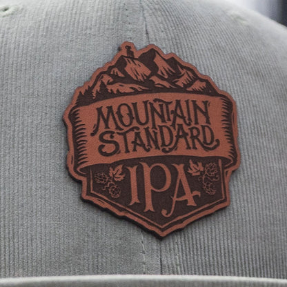 Odell mountain standard leather patch on light olive, corduroy flat bill hat