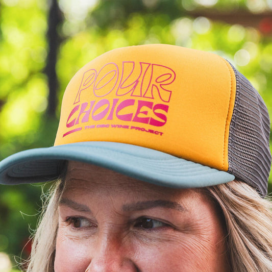 Wine Project Pour Choices foam trucker hat, Magenta text on gold background