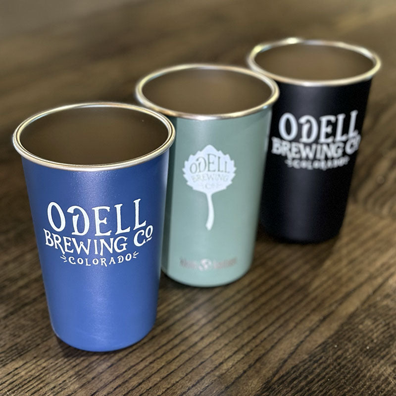 Three stainless steel mugs with Odell Brewing written on one side and the Odell Brewing leaf on the other side